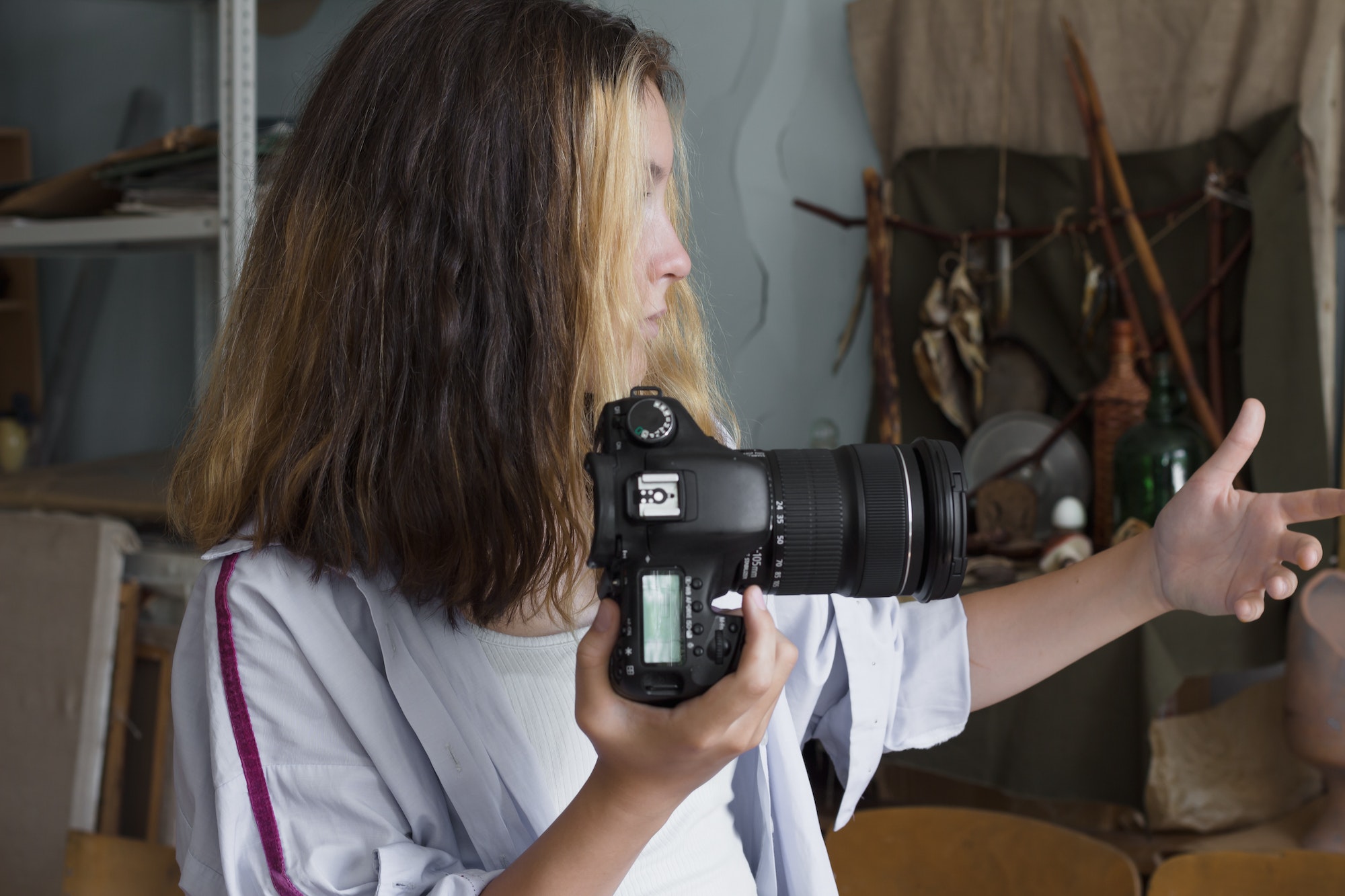 Beautiful teenage girl learns the basics of photography and takes a photo in an art class
